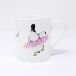 A gentoo penguin wearing a pink tutu on an espresso mug - handle facing right