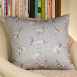 A cushion featuring a hare and dandelion design