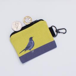 A key fob in the form of a purse with a blackbird design