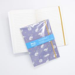 A notebook with elasticated enclosure with a hare and dandelion design showing open pages